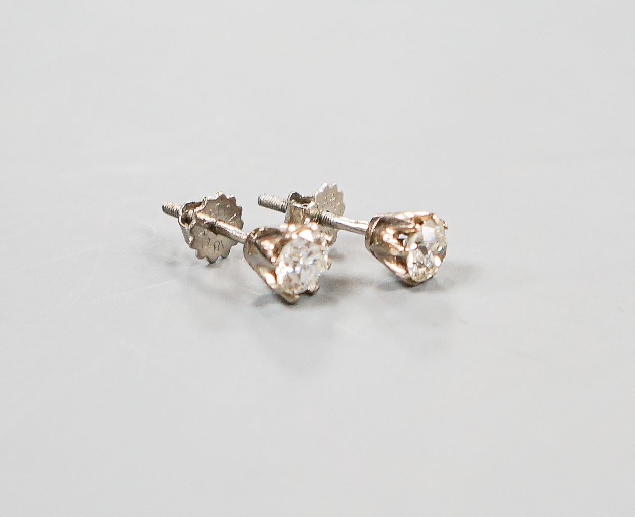 A pair of 18ct white metal and solitaire diamond ear studs, gross weight 2.4 grams